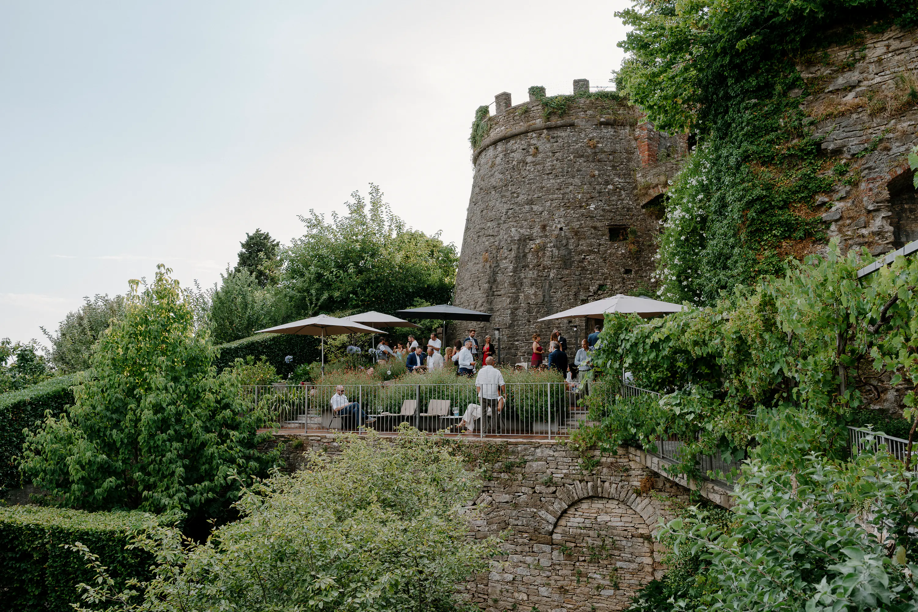 Ospiti del matrimonio nel giardino ai piedi di una torre medievale